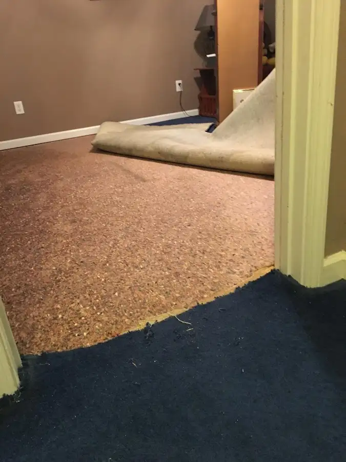 Carpet pad removal revealing water damage during Water Mitigation Services in Greensburg